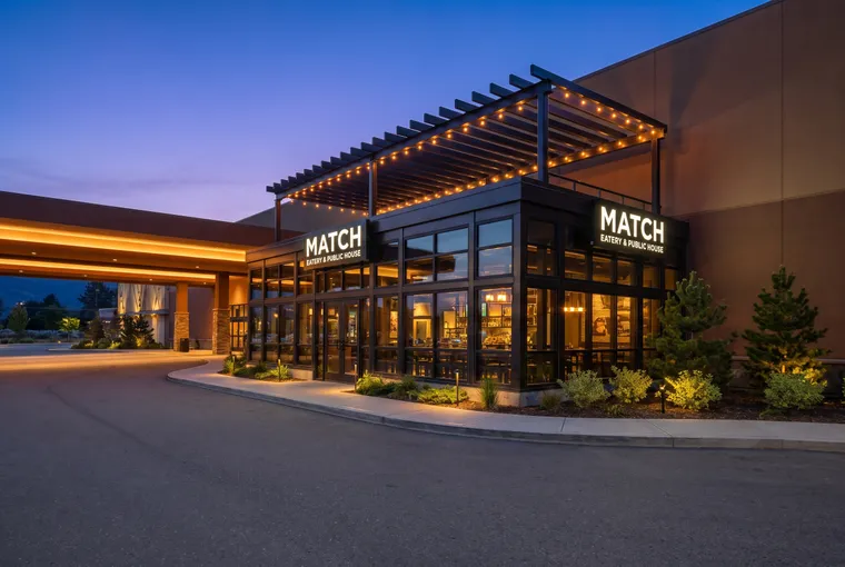 Glass-walled pub patio with a rooftop pergola at dusk
