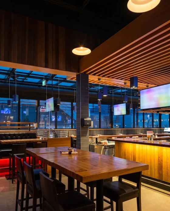Empty pub with long tables and a wood-slat ceiling